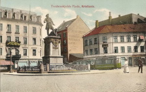 Tordenskiolds plass i Kristiania med Tordenskioldstatuen og Hotel Paris i bakgrunnen. Håndkolorert postkort fra ca. 1905, tilhører Oslo Byarkiv. Fra Oslobilder.
